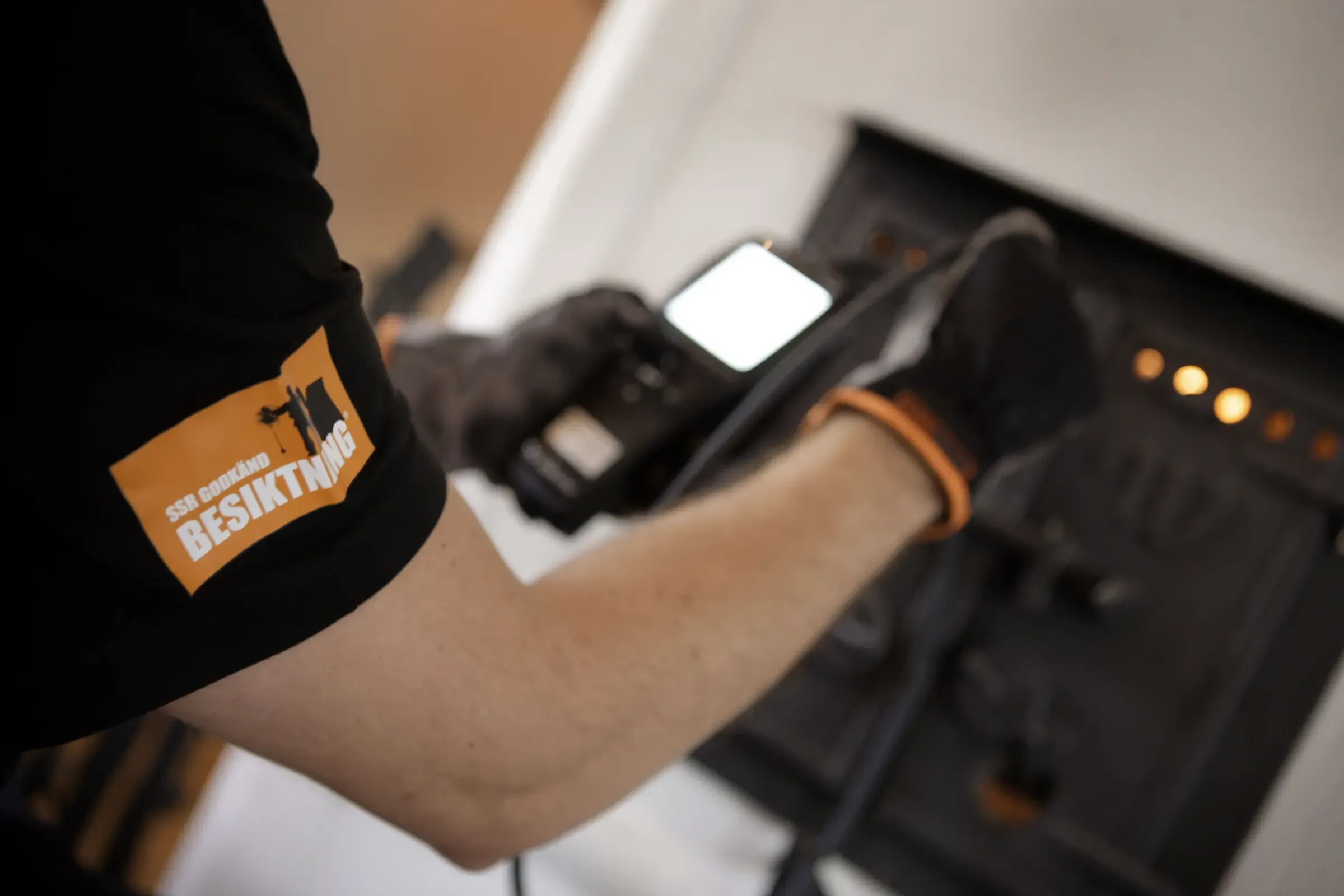 Man håller i elektriska verktyg för besiktning av eldstad